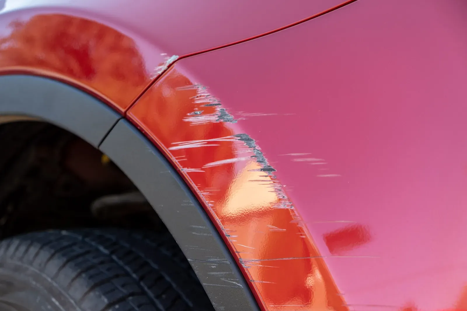 Paint transfer scuffed onto a car bumper corner from another vehicle