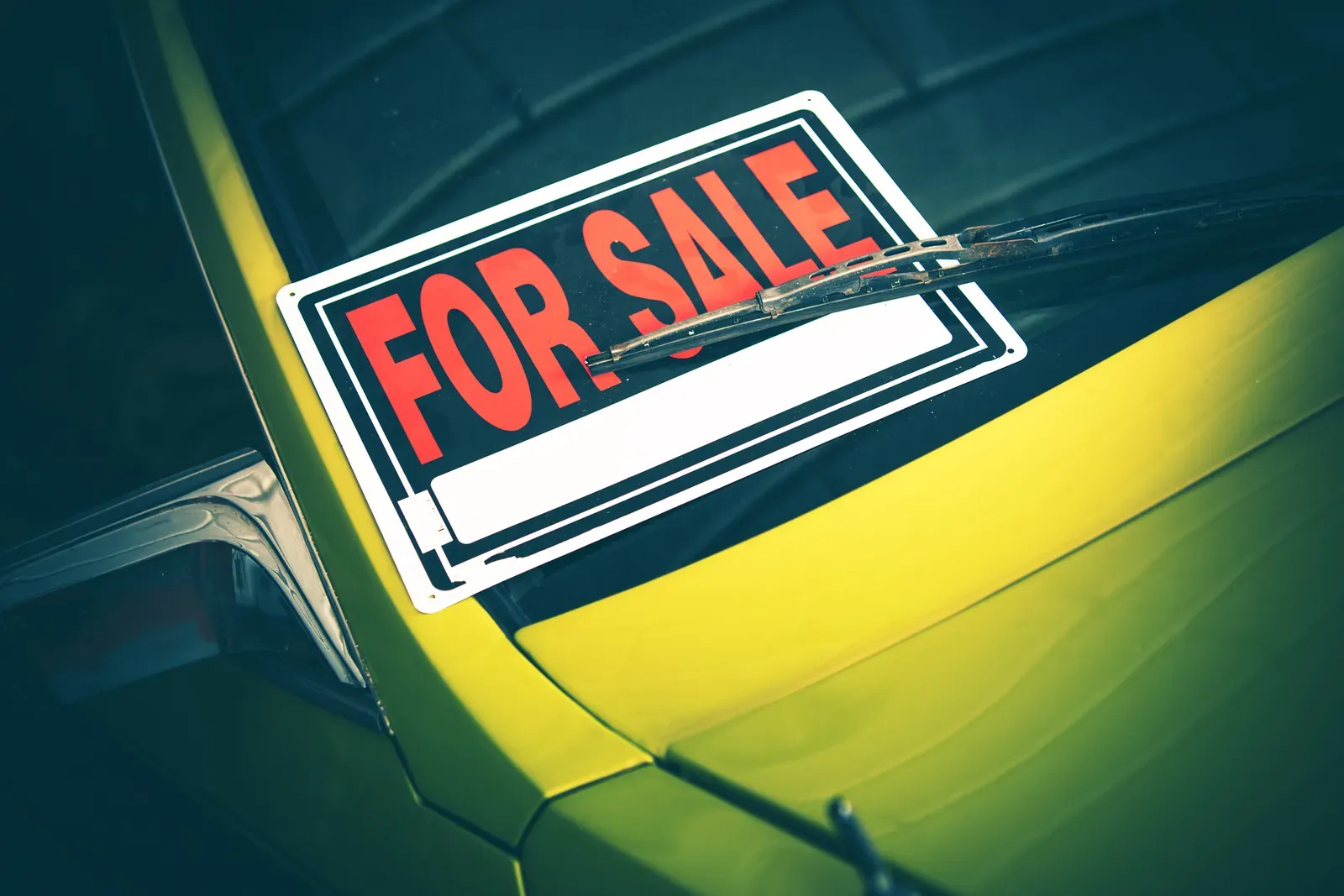 For-sale sign displayed on a car windshield