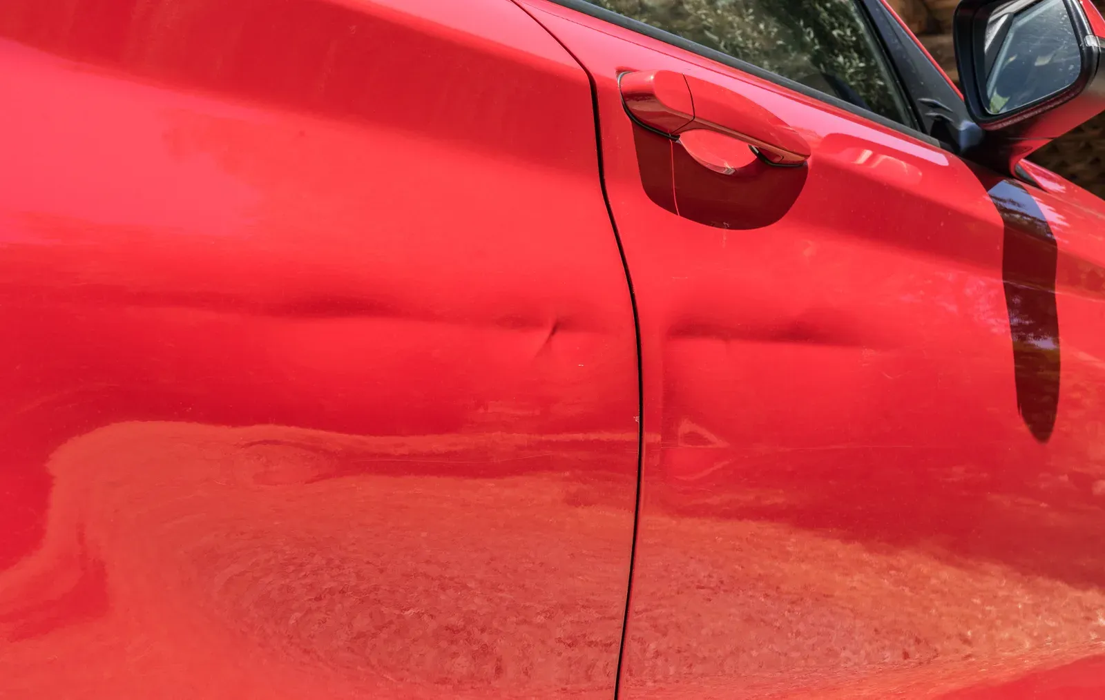 Damaged door panel on a parked car brought in for repair in Savage, MN