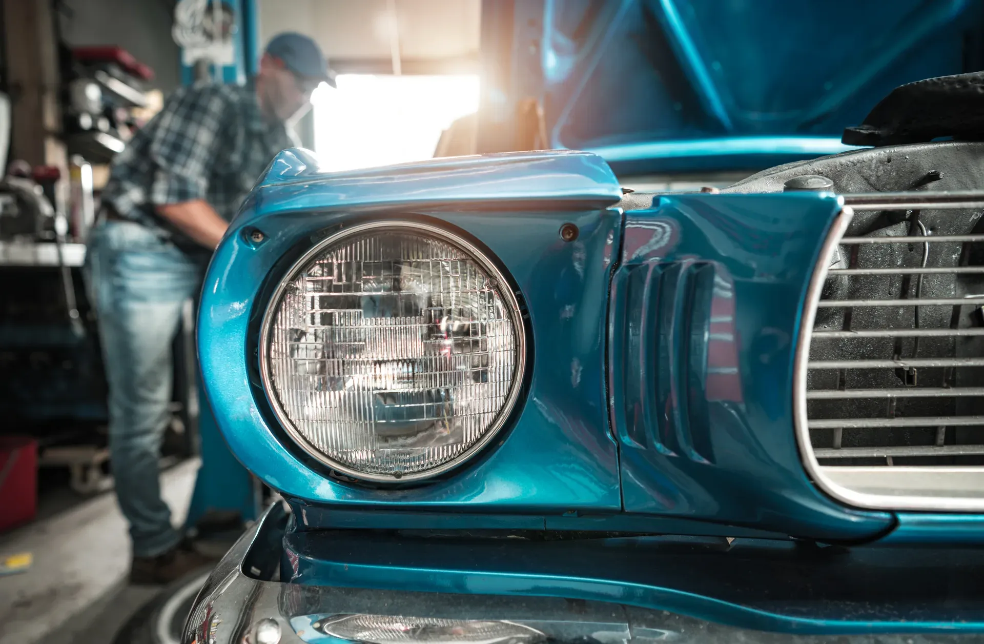 Technician working carefully on a vehicle panel in the shop