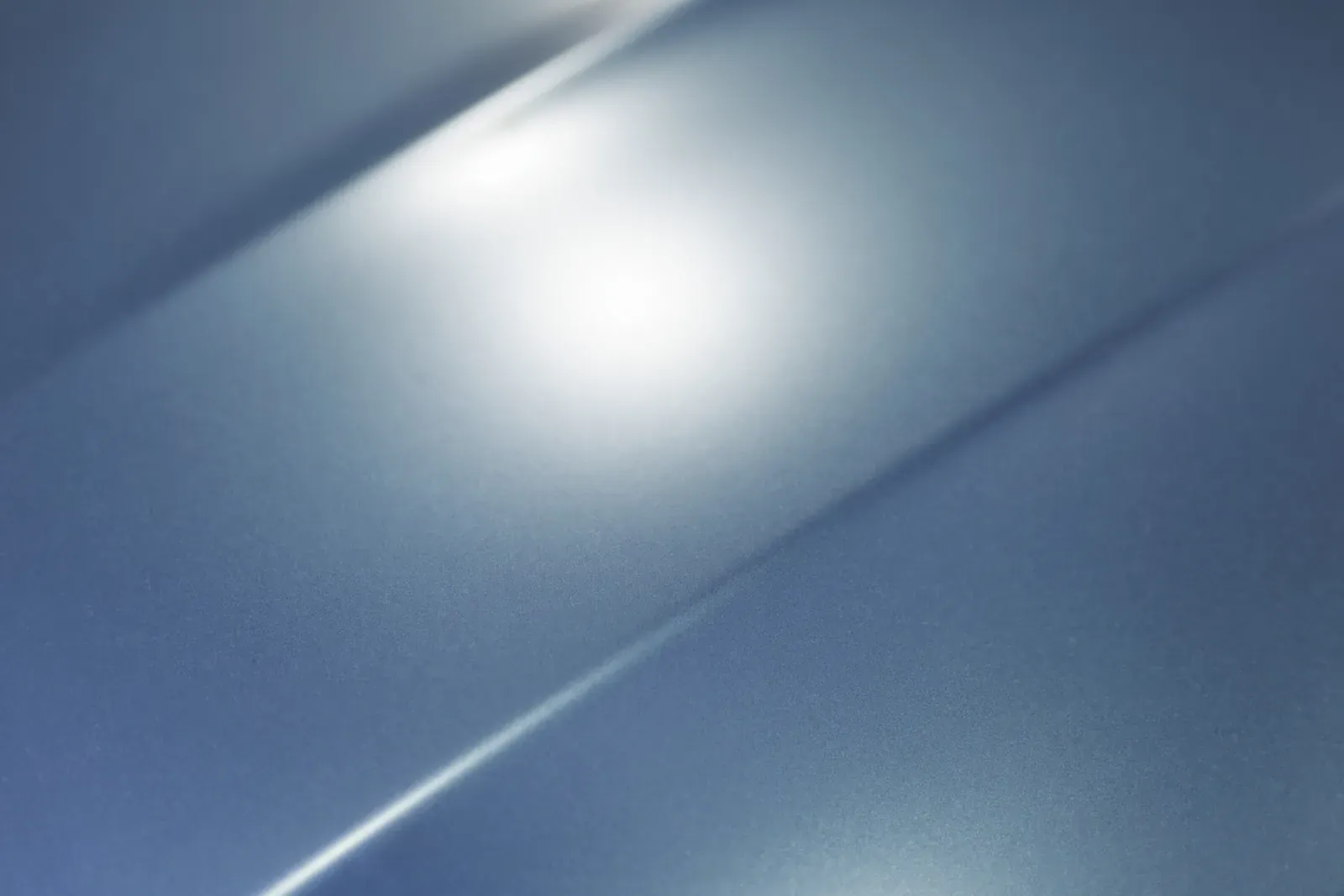 Macro view of glossy metallic automotive paint on a body panel