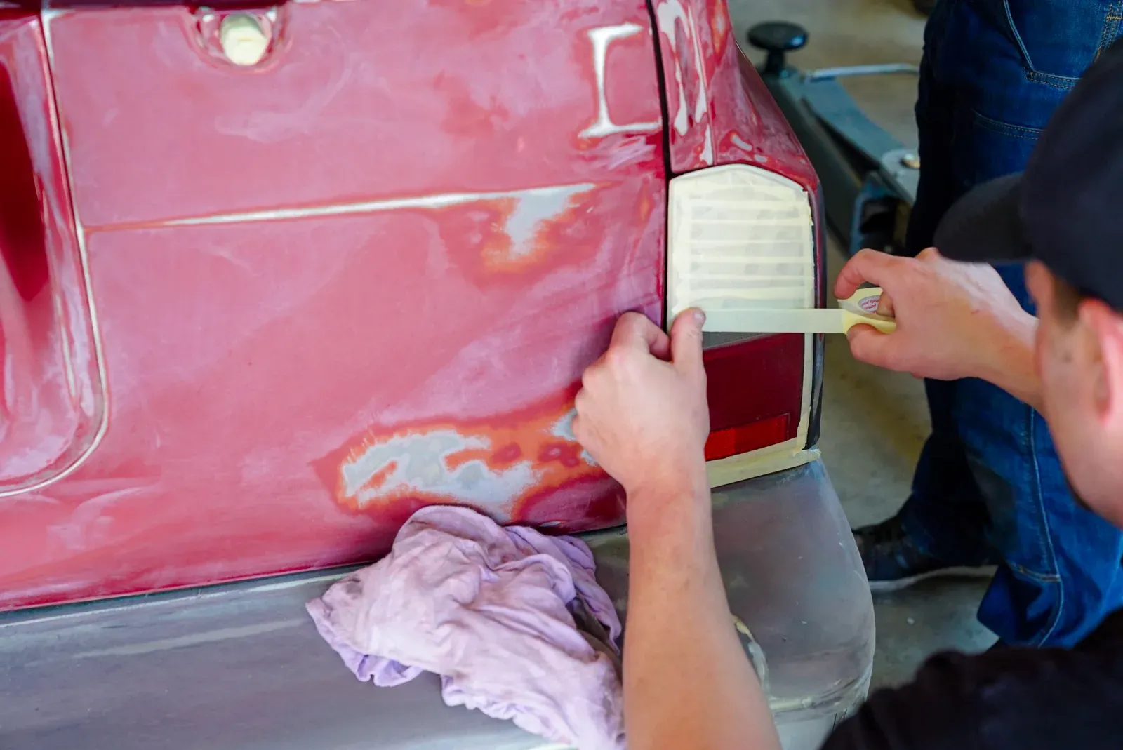 Technician sanding and prepping a vehicle panel for paint at Prime Auto Body in Savage, MN