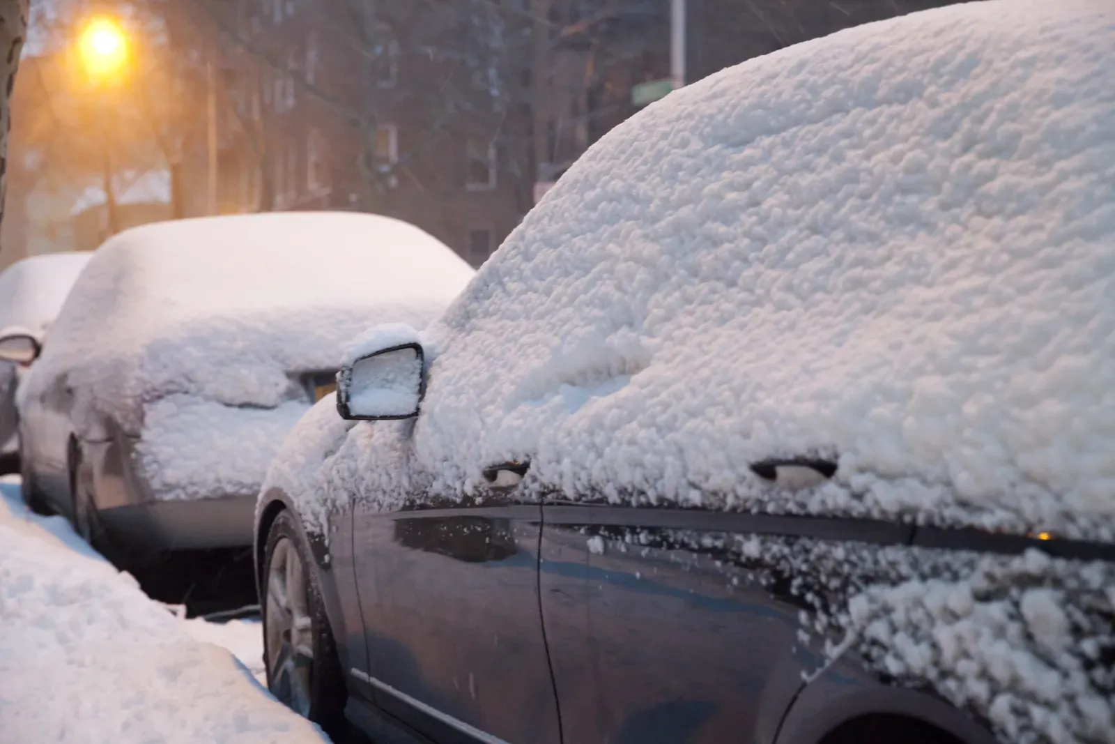 Snow-covered cars in a Minnesota parking lot after a winter storm