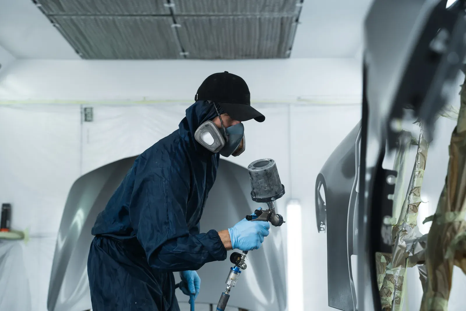 Dark panel receiving basecoat in the booth for an Eagan, MN vehicle