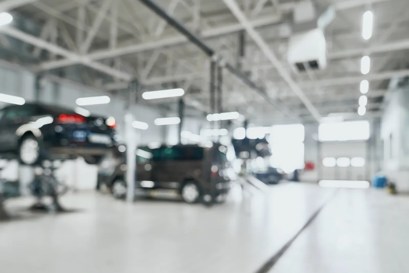 Technician working on a vehicle in a service bay at Prime Auto Body in Savage, MN