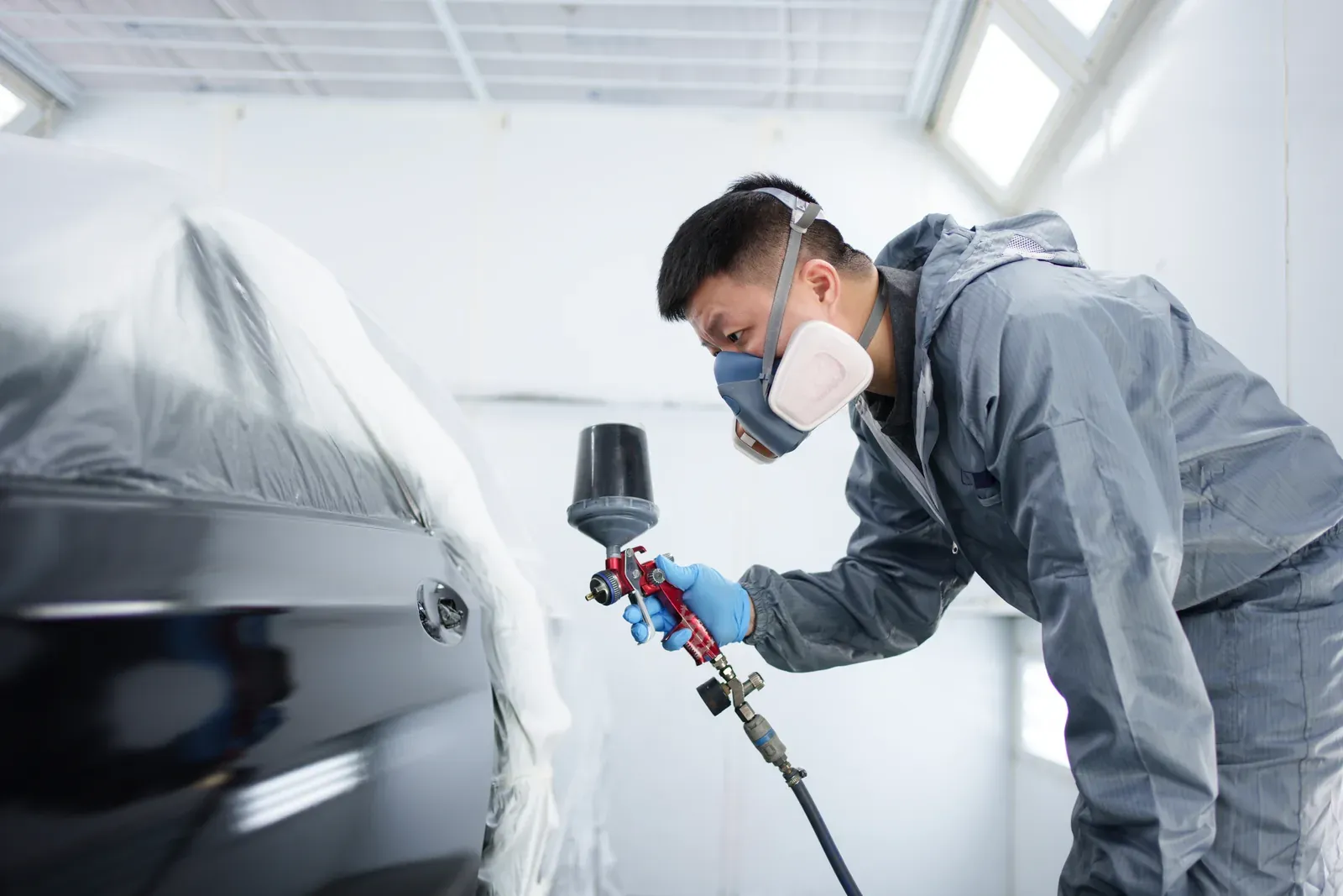 Gray sedan being refinished in the spray booth for a Burnsville, MN customer